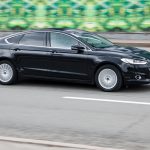 Ford Mondeo MK5 goes fast on the asphalt road. Fourth-generation Ford Mondeo in city street